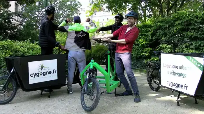 Des personnes heureuses autour d'un vélo-cargo Cygogne 