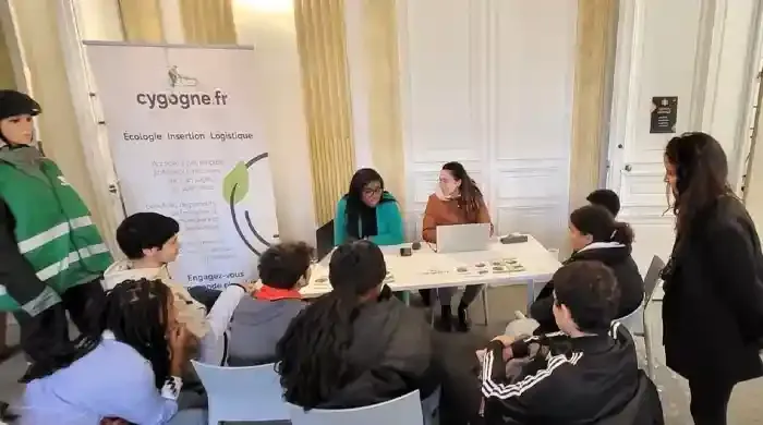 Groupe de personnes autour d'une table qui parlent de cygogne 