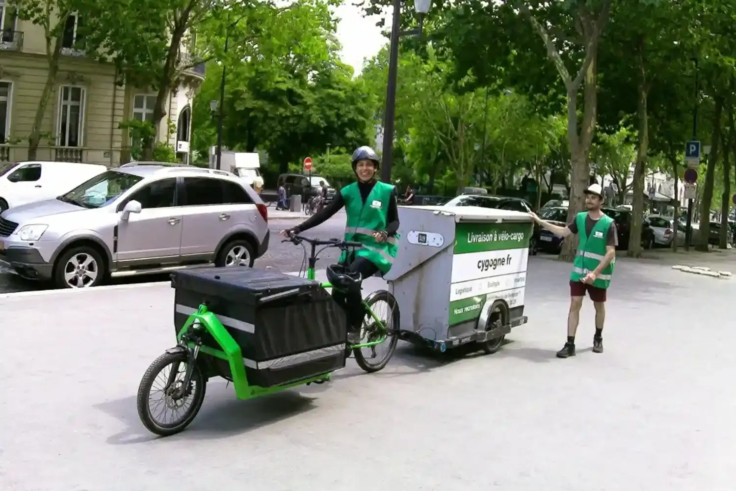 Deux hommes à côté d'un vélo-cargo et d'une remorque 